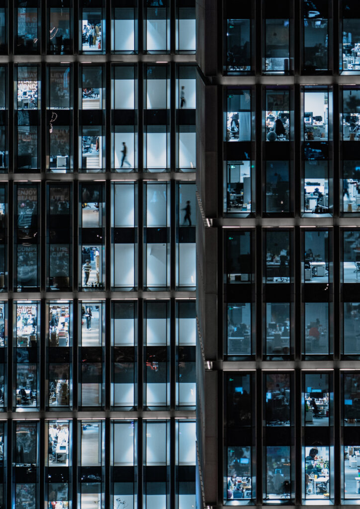Office Building Windows, Business People Working in Office Business Building at Night.
